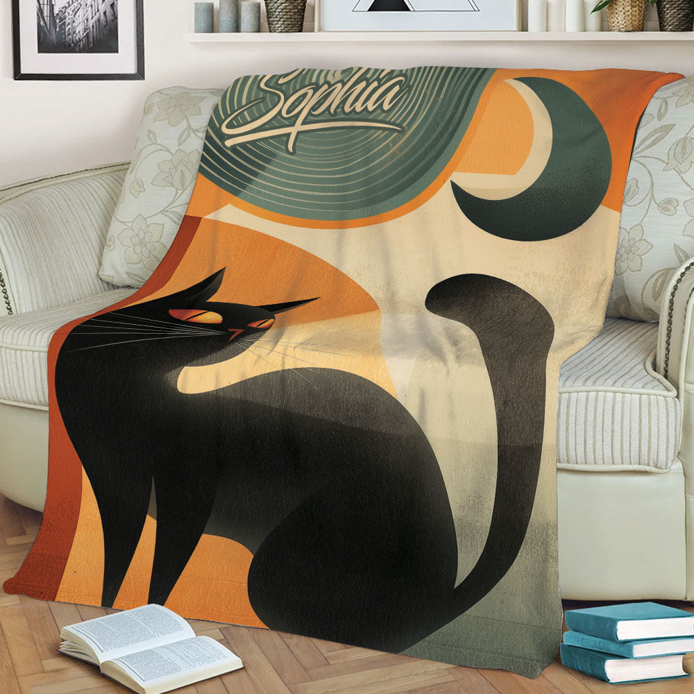 Close view of a black cat throw blanket with curved tail artwork, crescent moon detail, and retro styling