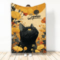 Black cat blanket with golden eyes surrounded by warm yellow and orange floral artwork