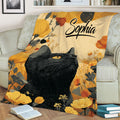 Black cat floral throw blanket draped over a sofa in a cozy living room setting