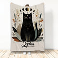 Black cat throw blanket with moon phases, botanical accents, stars, and celestial artwork