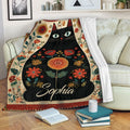 Black cat floral throw blanket draped over a sofa in a cozy living room setting