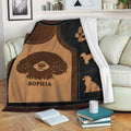 Poodle throw blanket draped over a sofa with curly dog artwork and warm leather-look colors