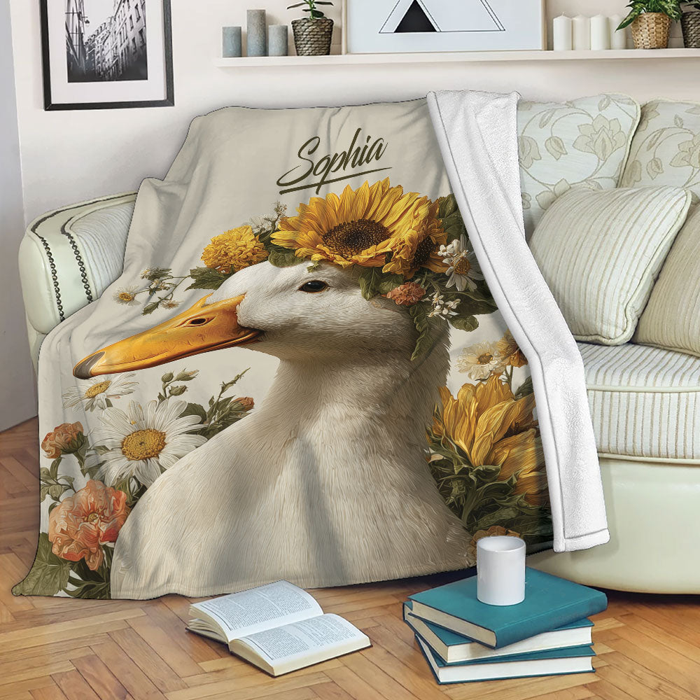 Floral duck throw blanket draped over a sofa with sunflower and garden flower artwork