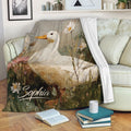 Duck blanket draped over a sofa with floral meadow artwork and rustic colors