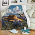 Texas throw blanket draped on a sofa with longhorn, cowboy hat, and bluebonnet design