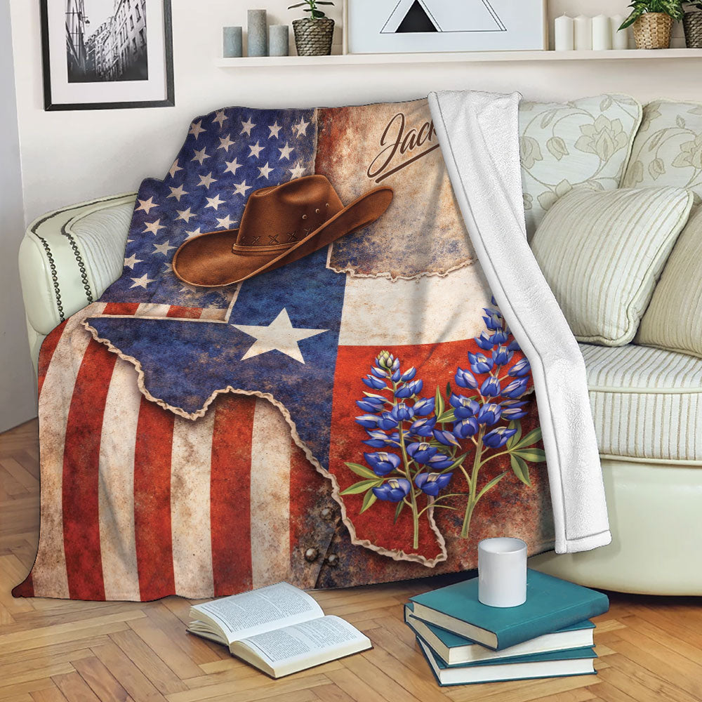 Texas blanket draped over a sofa with cowboy artwork, bluebonnets, stars, and rustic red, white, and blue styling