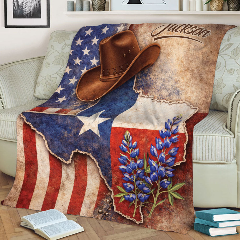 Rustic Texas throw blanket displayed on a sofa with a cowboy hat, bluebonnets, and vintage flag artwork