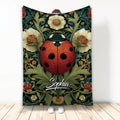 Ladybug throw blanket with ornate red beetle and botanical floral artwork displayed in a room