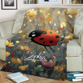 Close view of a ladybug throw blanket with colorful flowers, glowing accents, and detailed insect artwork