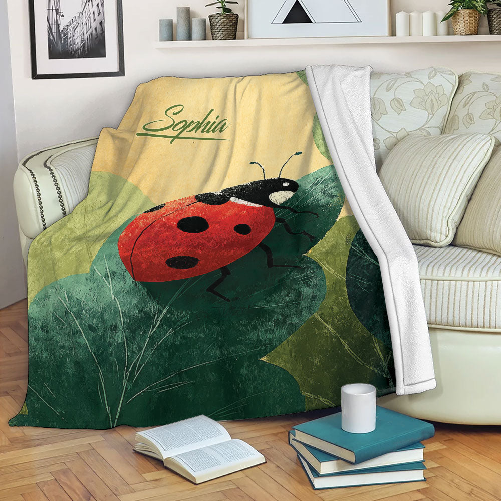 Ladybug throw blanket draped over a sofa with leafy garden artwork