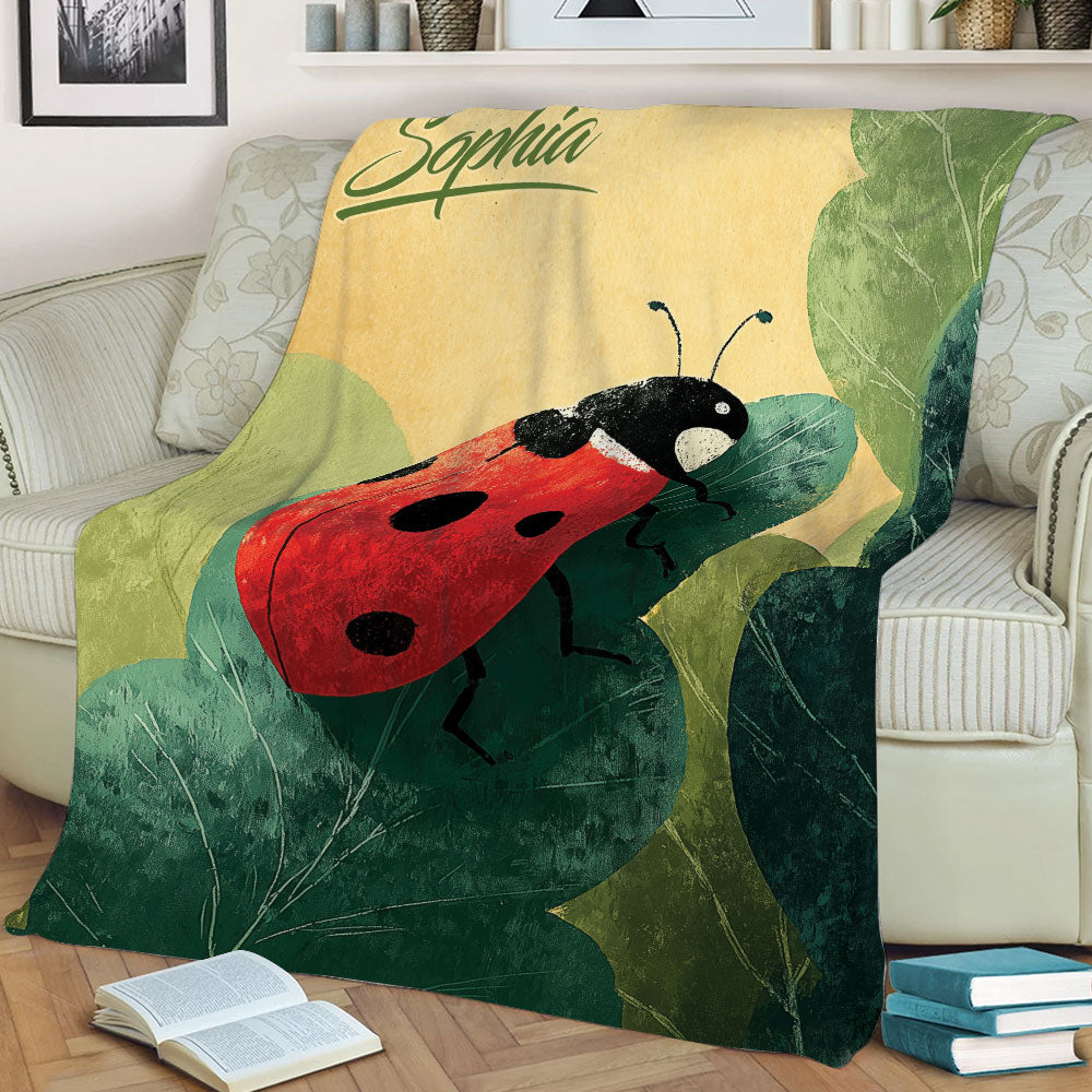 Close view of a red ladybug blanket displayed on a couch with botanical leaves