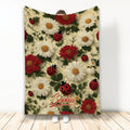 Ladybug throw blanket with red and white flowers, green foliage, and a garden-inspired pattern