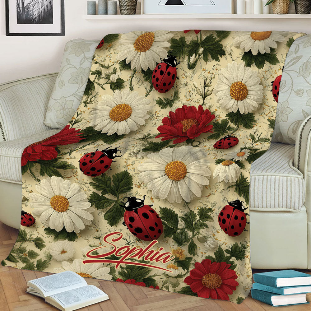 Floral ladybug blanket displayed on a sofa with colorful flowers, greenery, and garden artwork