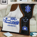 Close view of a custom paramedic blanket featuring ambulance artwork and emergency medical symbols