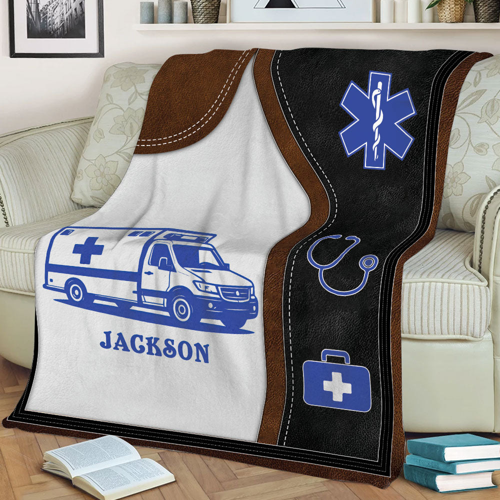 Close view of a custom paramedic blanket featuring ambulance artwork and emergency medical symbols