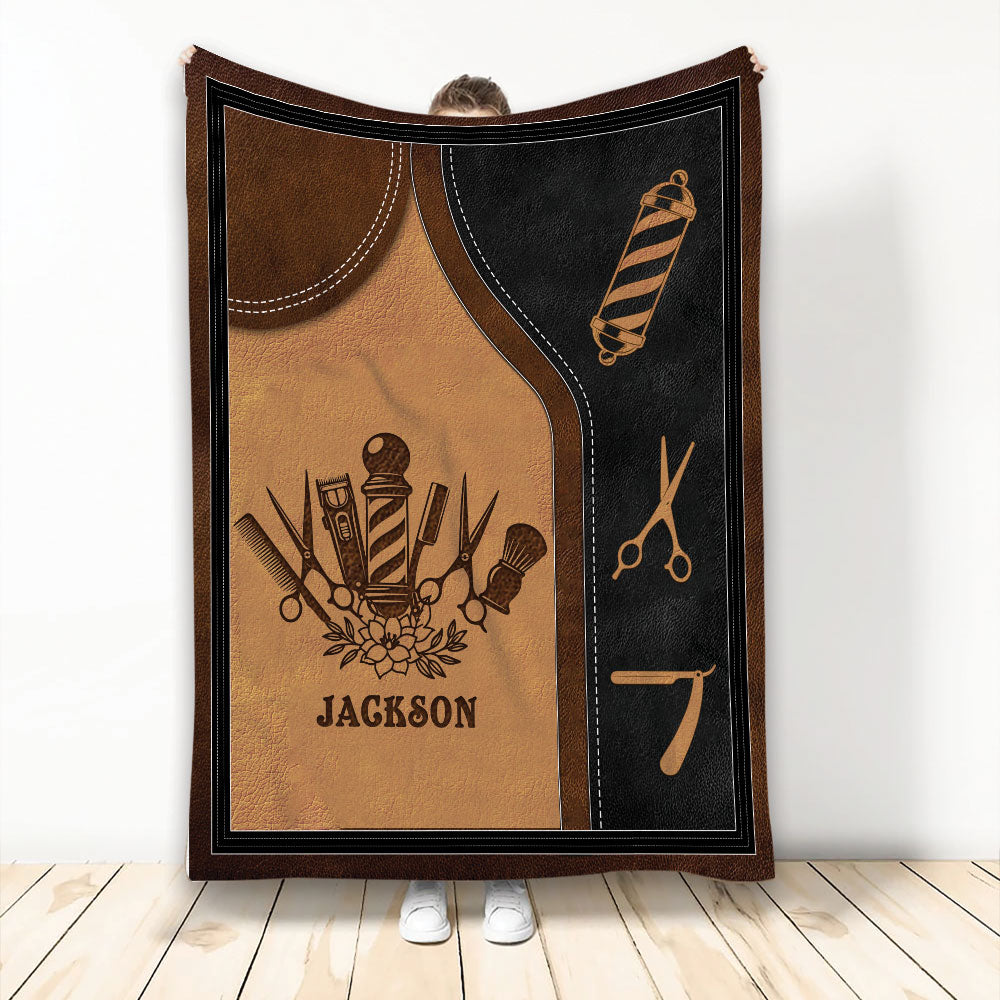 Barber throw blanket displayed upright with barber tools, striped barber pole, and warm brown black artwork