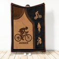 Cyclist throw blanket featuring bicycle rider silhouettes on a brown and black road-inspired design