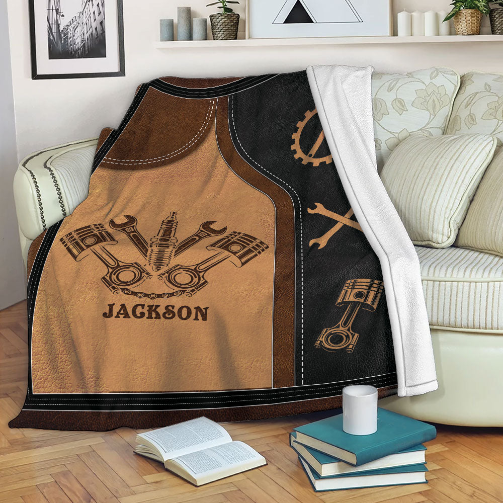 Custom mechanic blanket displayed on a sofa with piston and wrench automotive artwork