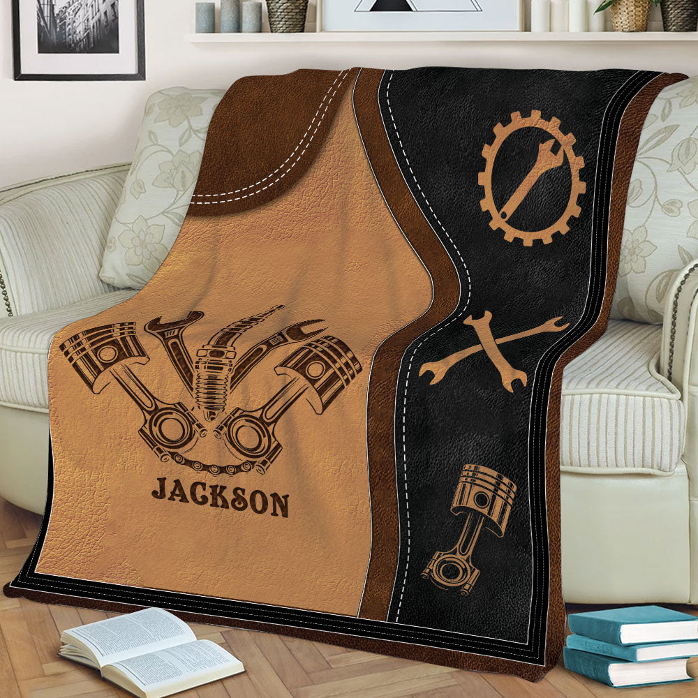 Automotive mechanic throw blanket draped over a sofa with pistons and crossed wrench design