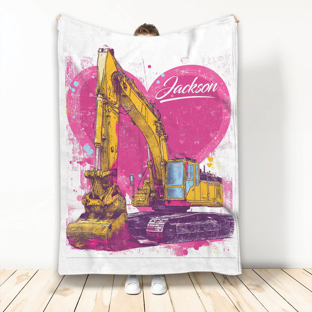 Excavator blanket held up indoors with bold yellow construction vehicle artwork and bright pink grunge accents