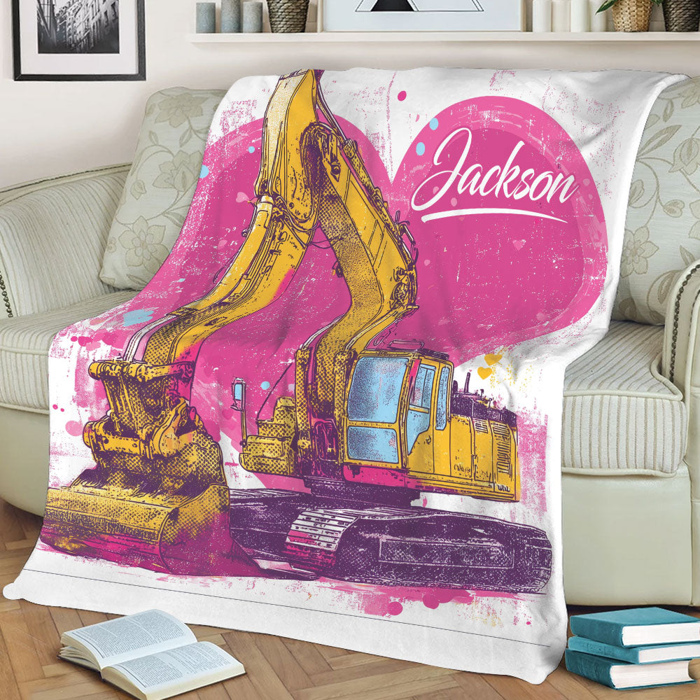 Excavator blanket draped over a chair featuring bold yellow machinery and vibrant pink artwork