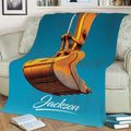 Close lifestyle view of an orange excavator design on a turquoise couch throw blanket