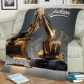 Large excavator blanket displayed on a couch with dramatic construction machinery artwork