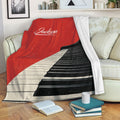 Red piano throw blanket draped over a sofa in a cozy living room setting