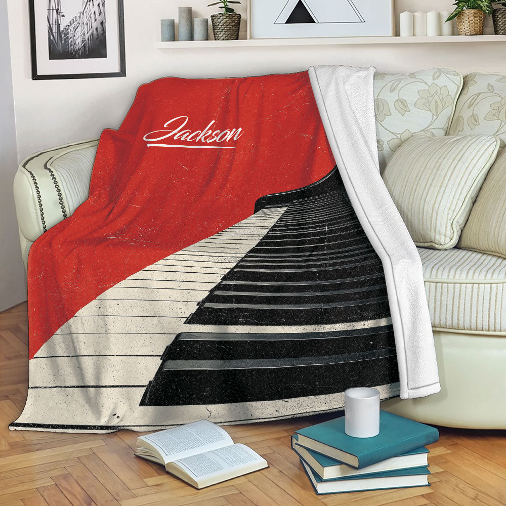 Red piano throw blanket draped over a sofa in a cozy living room setting