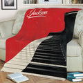 Grand piano keyboard blanket styled across a sofa with books and home decor