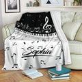 Piano throw blanket draped over a sofa with keyboard keys, musical notes, and black and white design