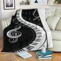 Piano throw blanket draped over a sofa with keyboard keys, music notes, and black and white musical artwork