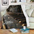 Piano blanket draped over a living room sofa with black and gold musical artwork and a cozy reading setting