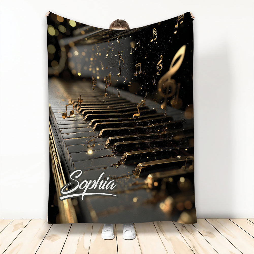 Piano throw blanket with glowing black and gold keys, floating musical notes, and elegant music artwork