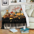 Piano throw blanket draped over a sofa with autumn leaves and keyboard artwork