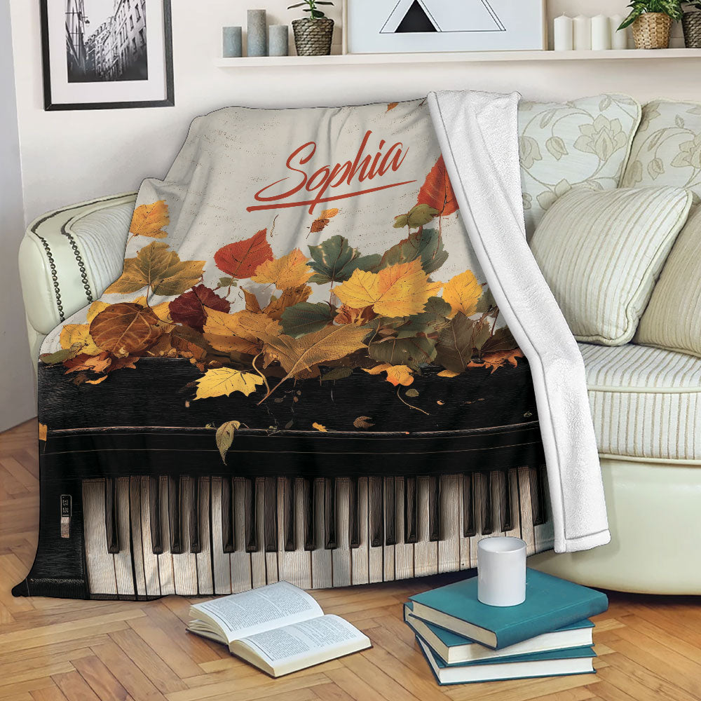 Piano throw blanket draped over a sofa with autumn leaves and keyboard artwork