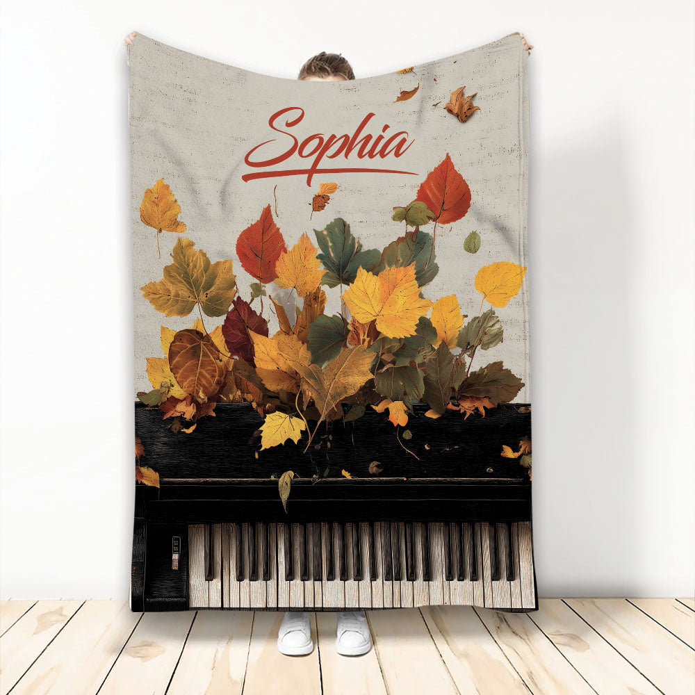 Piano throw blanket displayed with autumn leaves and full piano keyboard artwork