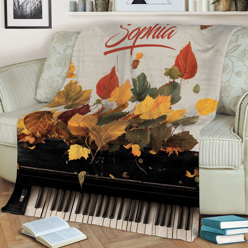 Close lifestyle view of piano blanket featuring colorful fall leaves and piano keys