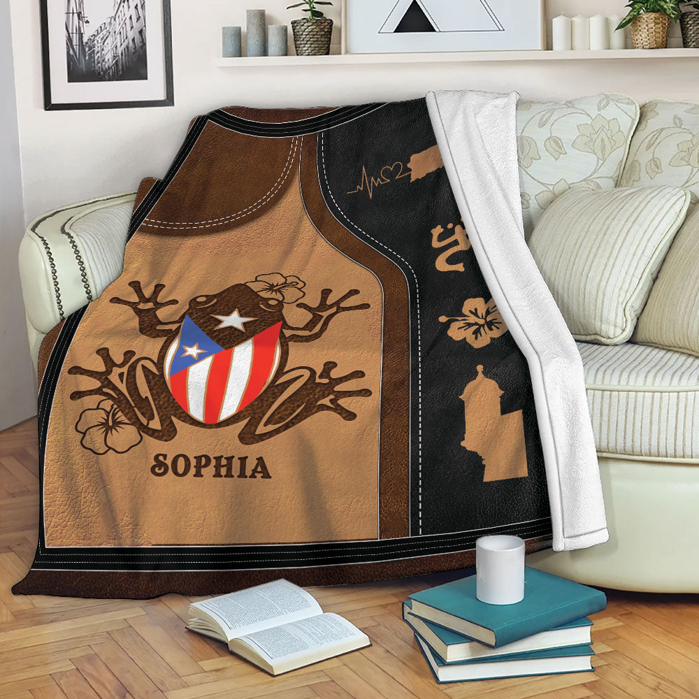 Puerto Rico blanket displayed on a sofa with coqui frog artwork, island symbols, and tropical floral details