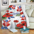 Puerto Rico blanket draped over a sofa with colorful flag-inspired frogs, hibiscus flowers, and tropical foliage