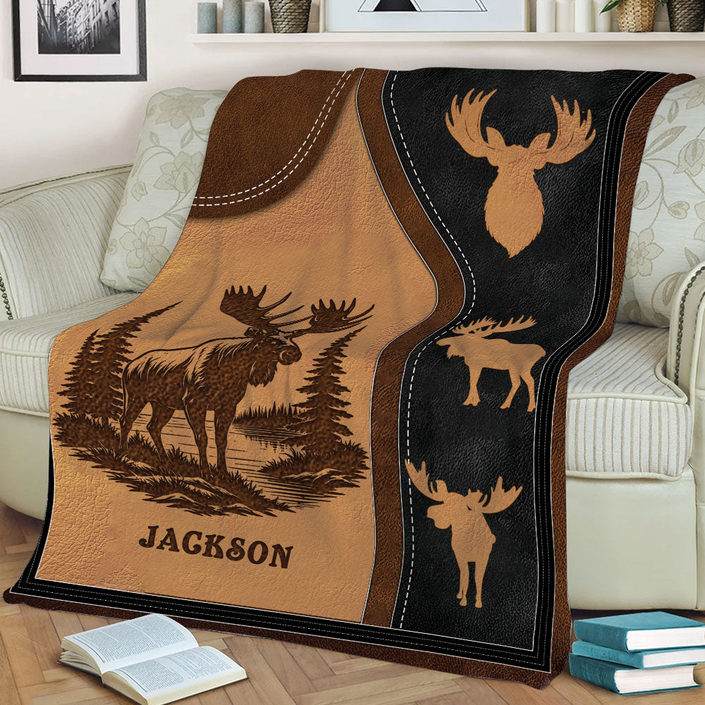Close view of a rustic moose blanket on a sofa with forest scenery and repeated moose silhouette details