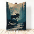 Moose throw blanket featuring a dark woodland silhouette, evergreen forest, mountain light, and flowing river