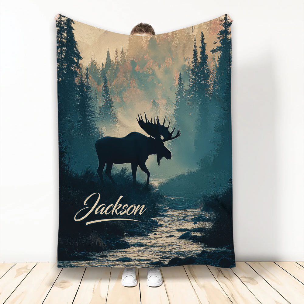 Moose throw blanket featuring a dark woodland silhouette, evergreen forest, mountain light, and flowing river