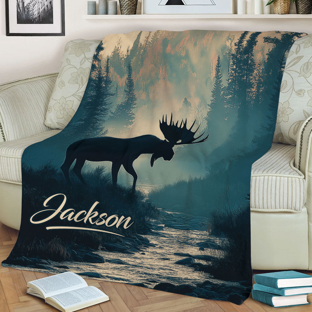Rustic moose throw blanket displayed on a sofa with evergreen trees, mountain scenery, and a river