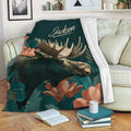 Moose throw blanket displayed on a sofa with woodland artwork and floral details