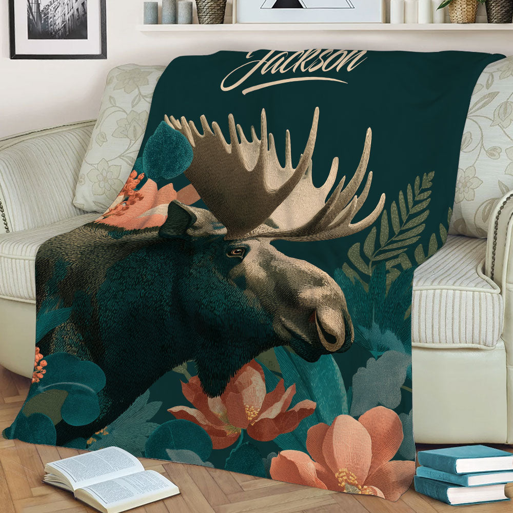 Close view of a moose blanket featuring detailed antlers, forest foliage, and flowers