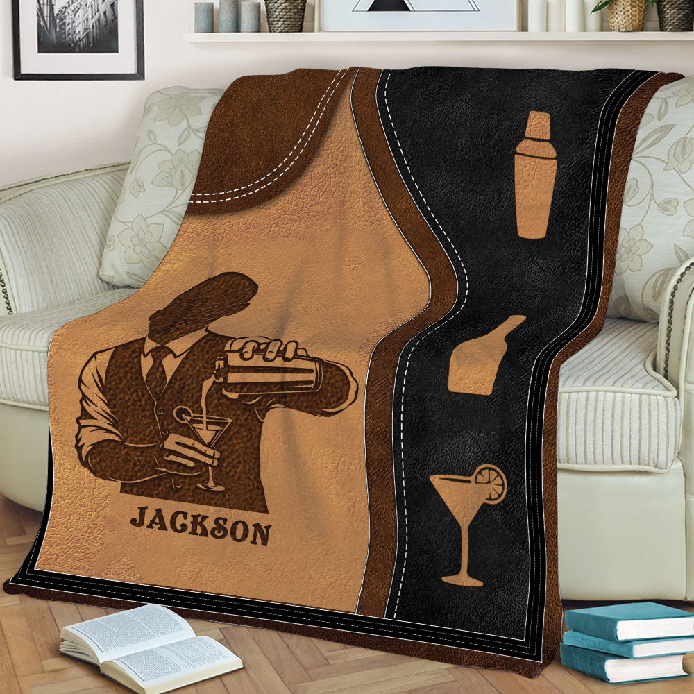 Close view of bartender and cocktail illustrations on a vintage-inspired brown and black blanket