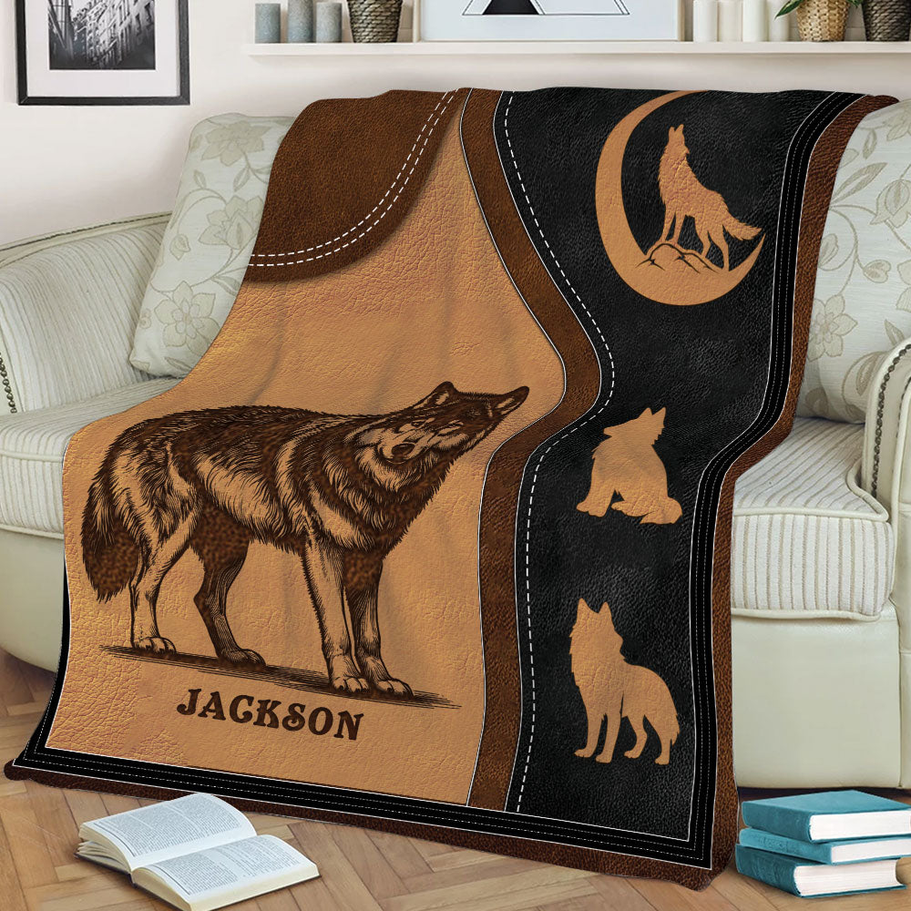 Close view of a wolf throw blanket featuring a detailed wolf illustration, crescent moon emblem, and earthy tones
