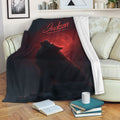 Wolf throw blanket draped over a sofa with a howling wolf and red moon artwork