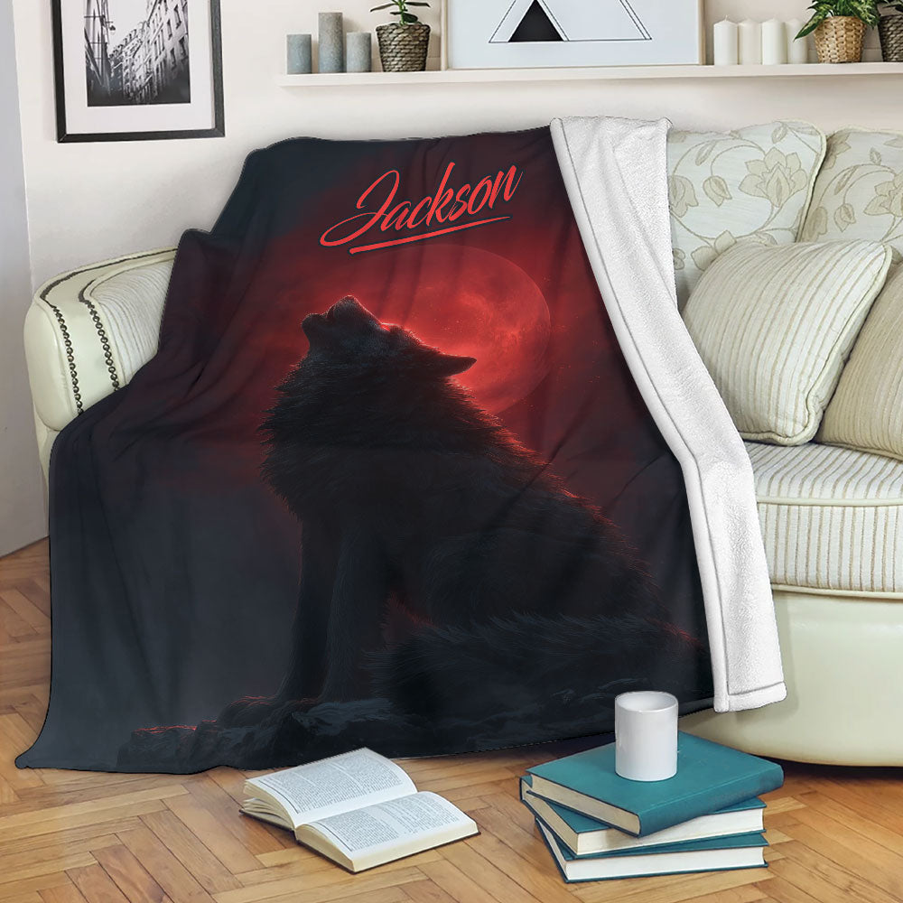 Wolf throw blanket draped over a sofa with a howling wolf and red moon artwork
